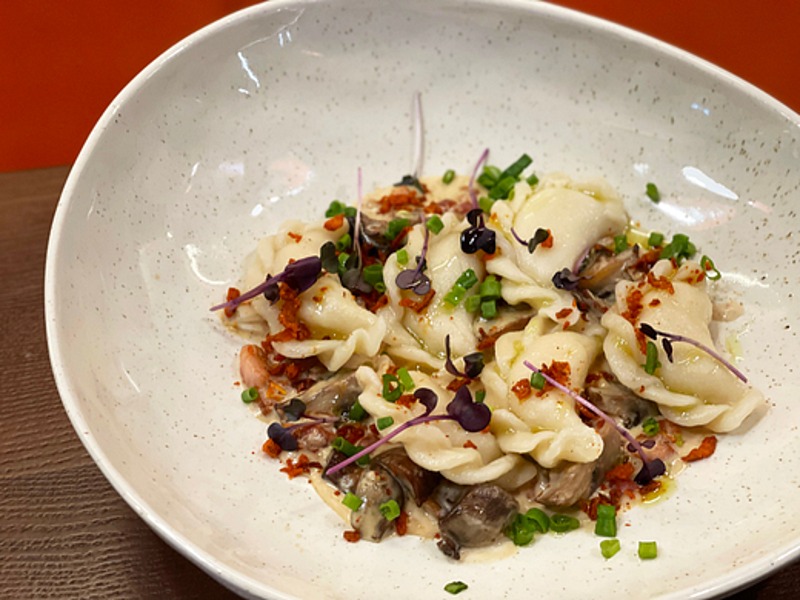 Вареники з картоплею у вершковому соусі, з в'яленими томатами, беконом і грибами